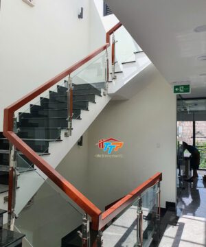Cầu thang kính cường lực 10mm, tay vịn gỗ hộp vuông mang lại vẻ đẹp bền vững cho ngôi nhà
